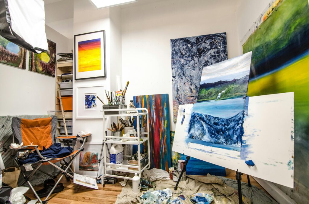 Colorful art studio showcasing vibrant paintings and creative workspace.